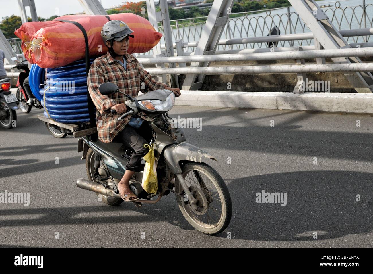 Loaded motorcycle on Trang Tien bridge in Hue, Vietnam Stock Photo