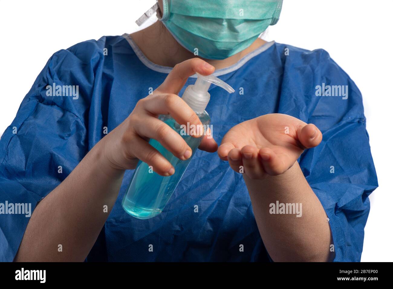 young asiatic physician woman wearing a green protection mask  using hand sanitizer on a white background Stock Photo