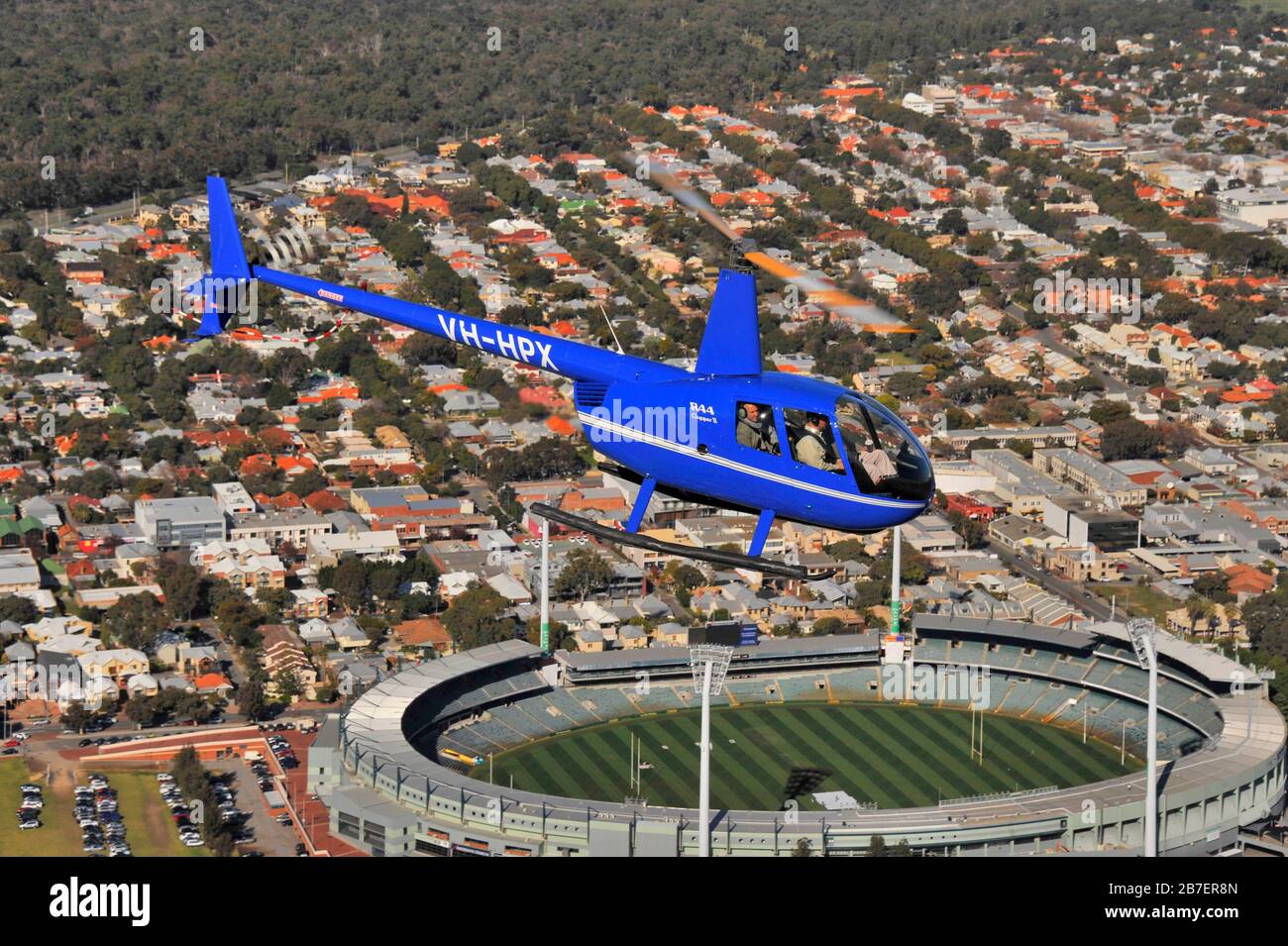 An air to air image of a Robinson R44 helicopter on a scenic flight over the city of Perth, Western Australia. Stock Photo