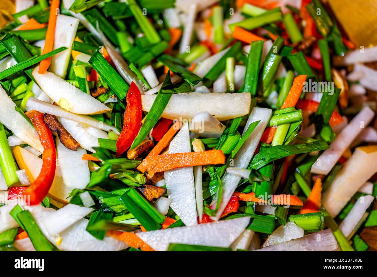 Macro closeup pattern of fresh chopped asian vegetables green chives, onions and carrots ingredients cooking white kimchi Stock Photo