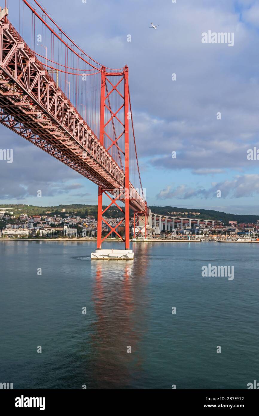 Left (south) bank of the Tagus river and the 25 de Abril Bridge, a suspension bridge connecting the city of Lisbon, capital of Portugal, to the munici Stock Photo