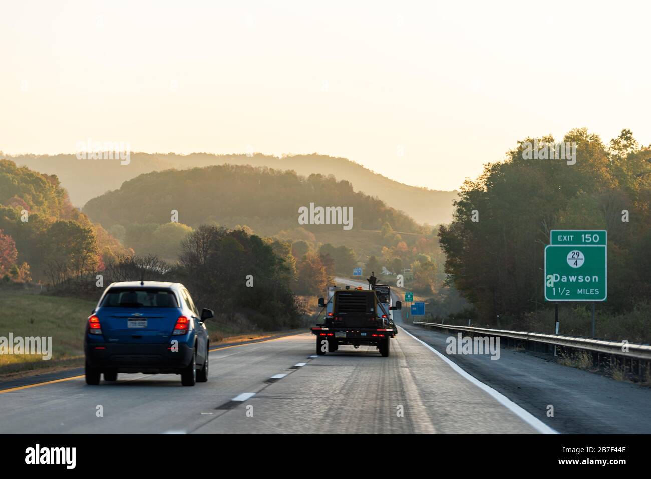 Dawson, USA - October 18, 2019: Fog mist road highway 64 driving in rural countryside in West Virginia with cars in traffic in morning sunrise sunligh Stock Photo