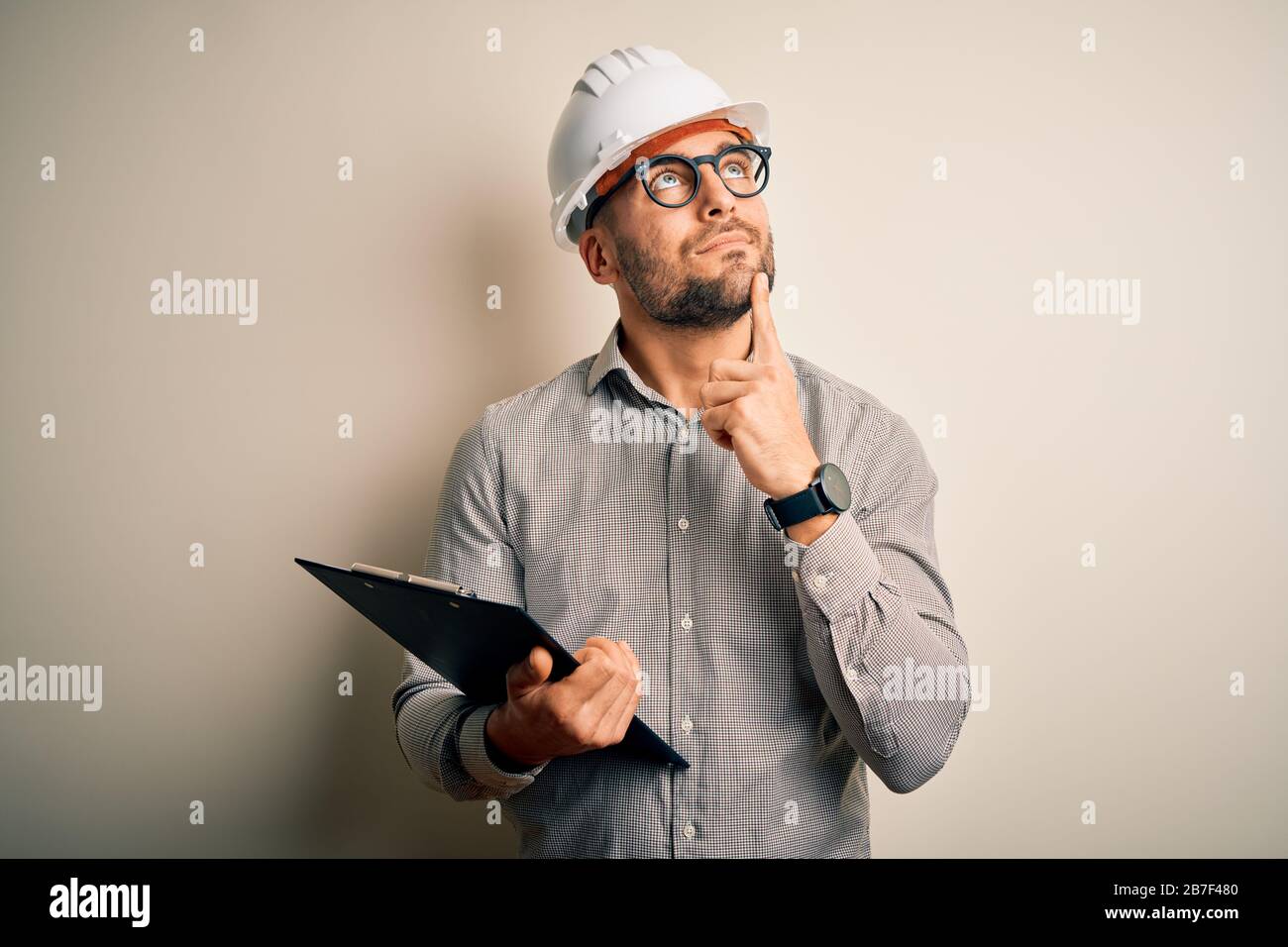 Young architect inspector man wearing builder safety helmet and using ...