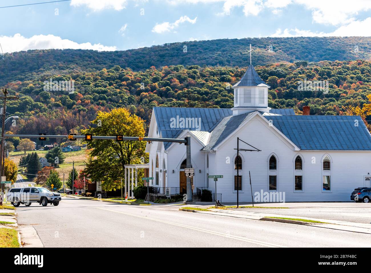Monterey, USA - October 18, 2019: View of main street road and autumn mountain trees with old architecture church building in appalachia in Highland C Stock Photo