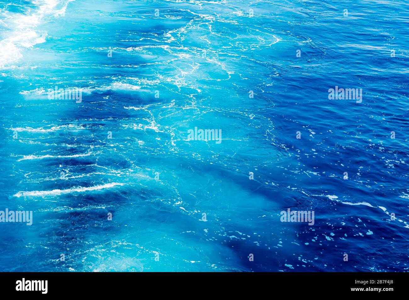 Trail on ocean water surface behind of fast moving powerful ship engines. Stock Photo
