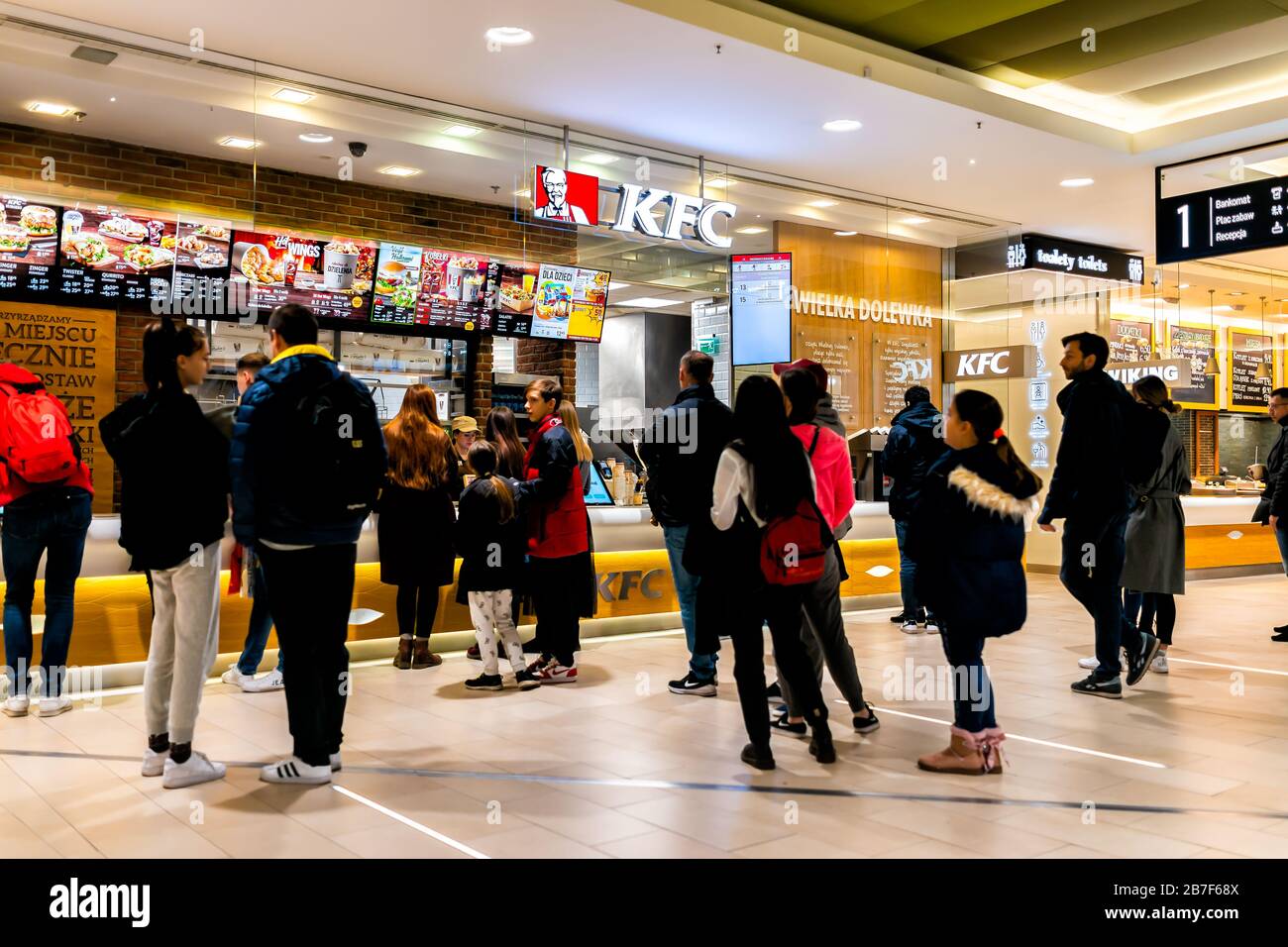 Warsaw, Poland - December 23, 2019: Food court with people standing waiting in line for KFC Kentucky Fried Chicken fast food chain restaurant inside o Stock Photo