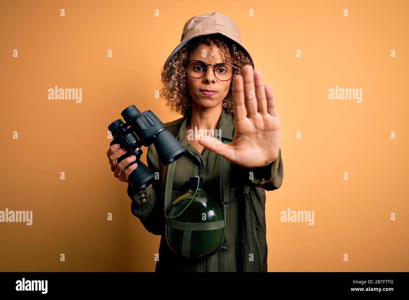 African american tourist woman wearing explorer hat and water canteen ...