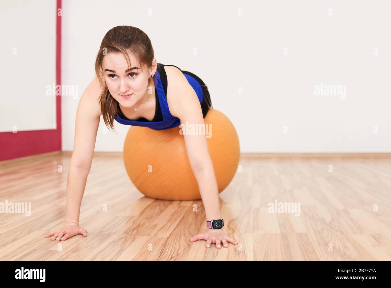 young petite woman is training by doing push up with exercise ball in gym  Stock Photo - Alamy