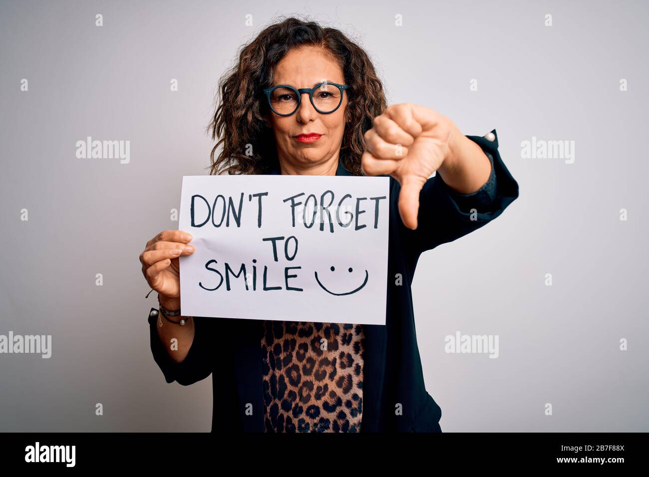 Middle age woman holding banner with dont forget smile message over ...