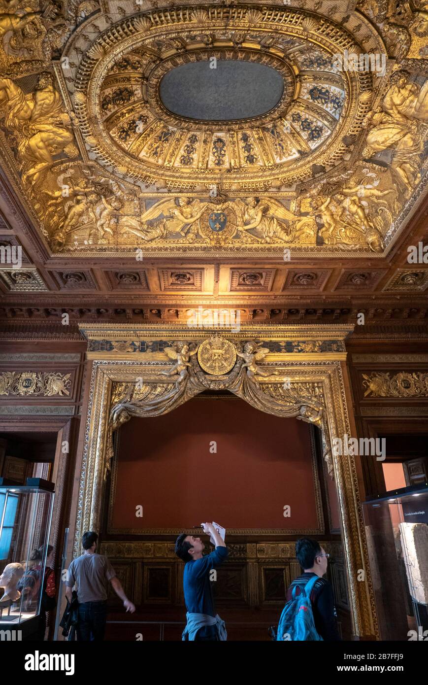 Asian tourist taking a picture of an ornate ceiling at the Louvre Museum in Paris, France, Europe Stock Photo