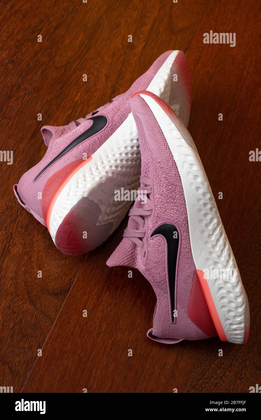 Pair of pink Nike Epic React 2 running shoes on hardwood floor Stock Photo  - Alamy