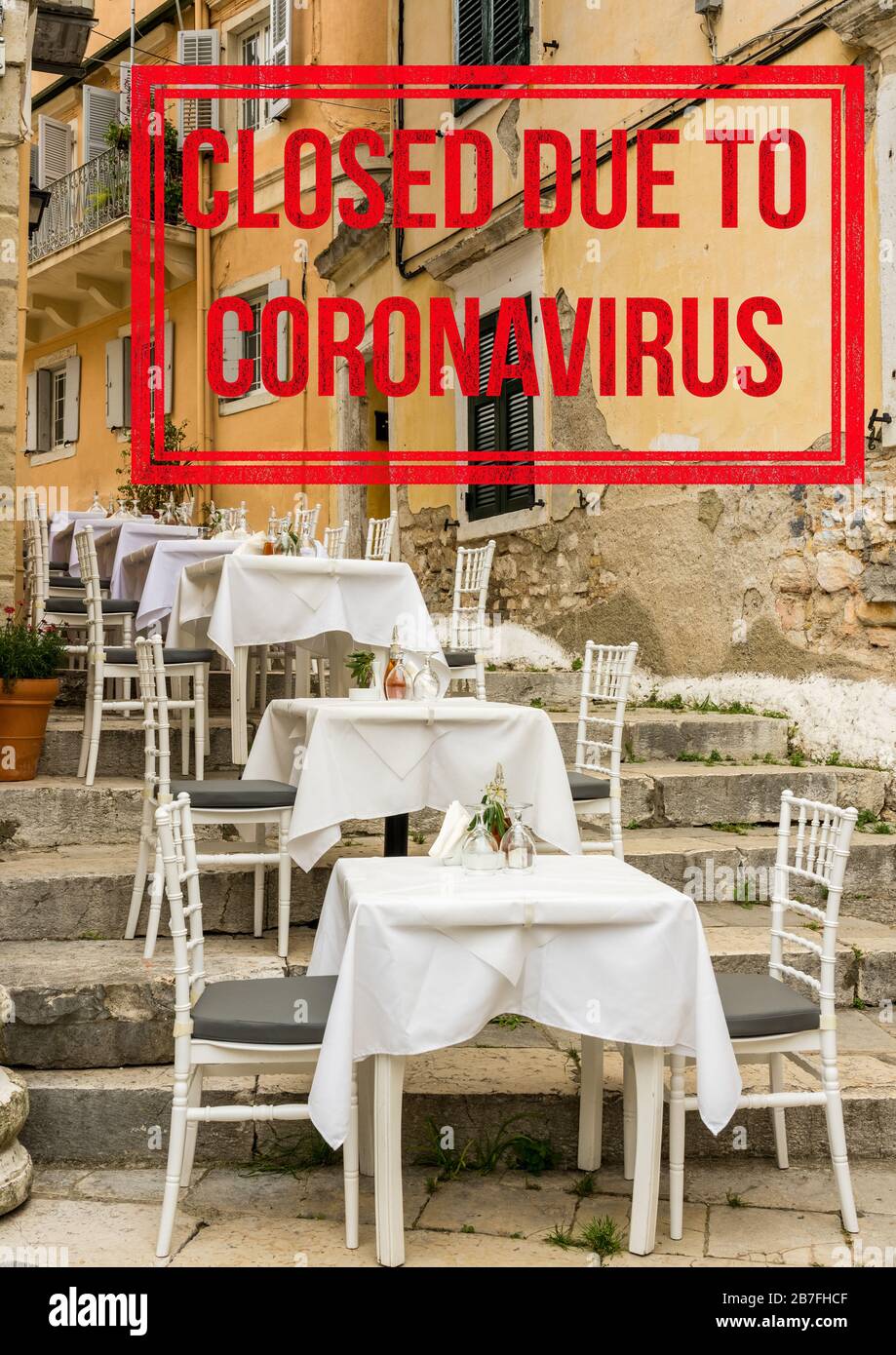 Empty tables and chairs of outdoor cafe in greek island of Corfu closed due to coronavirus Stock Photo