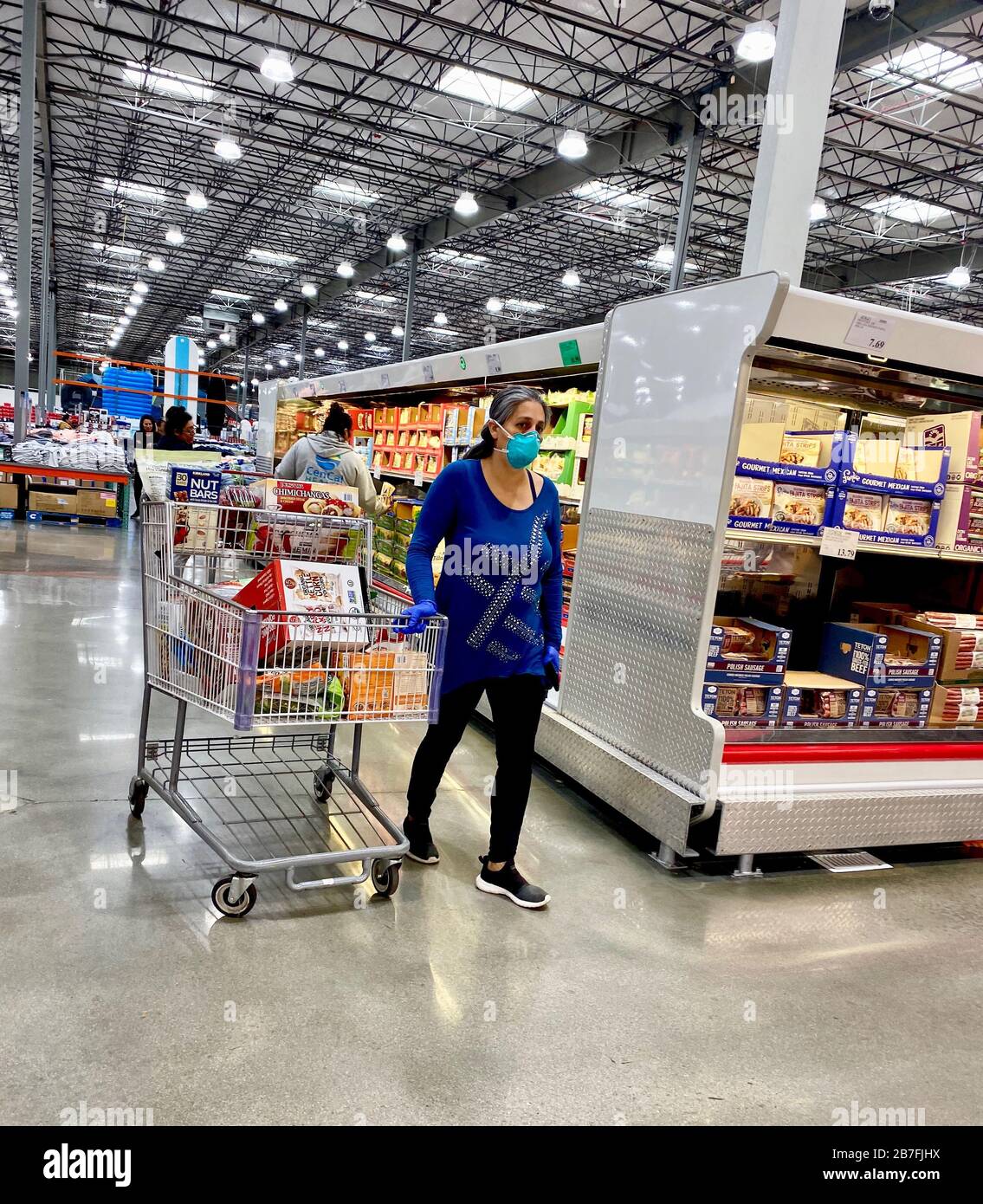 Santa Barbara, California, USA. 15th Mar, 2020. A run on water, meat and toilet paper as fears of the Covid-19 virus and a possible national mandatory quarantine send residents flocking to Costco, Goleta (Santa Barbara, CA) to stock up. Managers stand in front of the empty shelves doling out todayÃs shipment of bulk water, rationing it to two cases of water per buyer, and one pack of toilet paper. Many are filling up their cars with more than the allotted amount. Credit: ZUMA Press, Inc./Alamy Live News Stock Photo