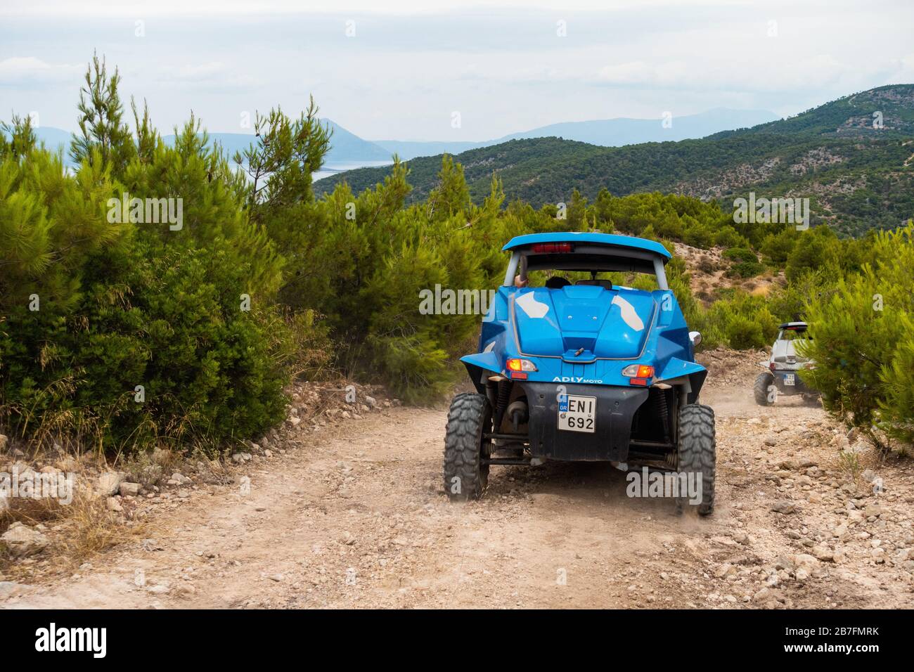 Tourists driving side by side all-terrain vehicles in Western Athens, near the Gulf of Corinth Stock Photo