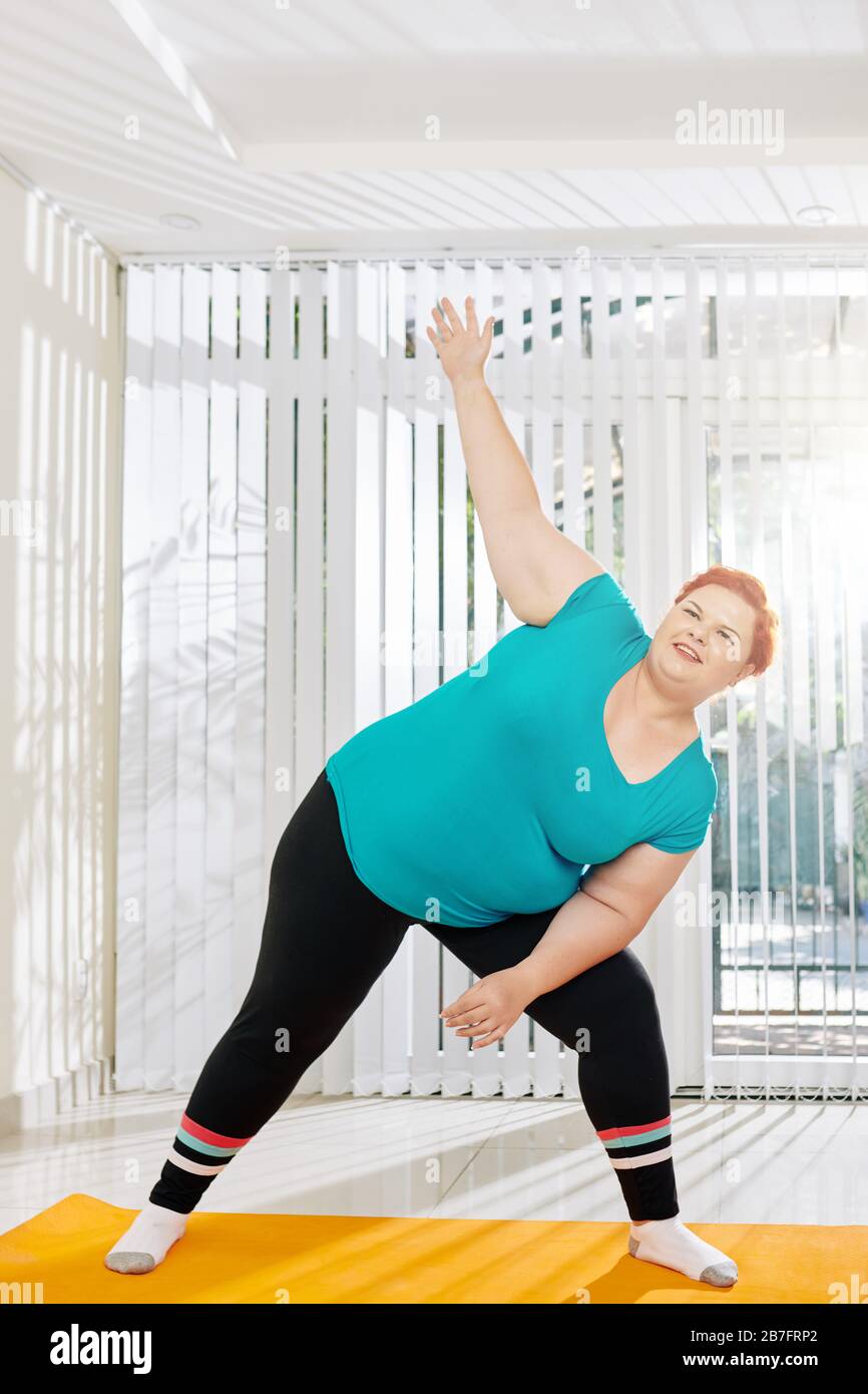 Happy young overweight woman attending fitness class in heath club Stock Photo