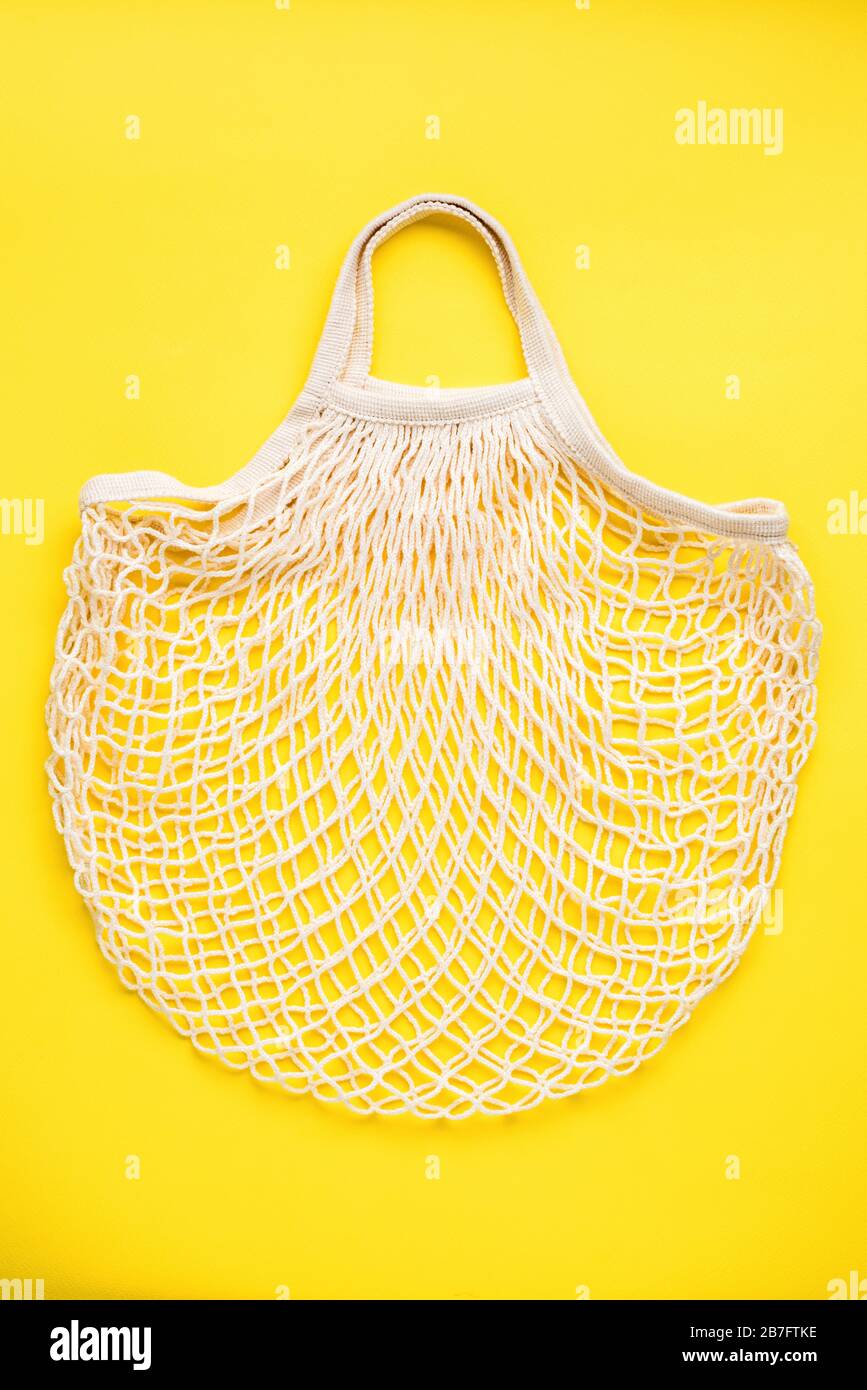 Reusable mesh shopping bag on yellow background. Eco friendly zero waste concept Stock Photo