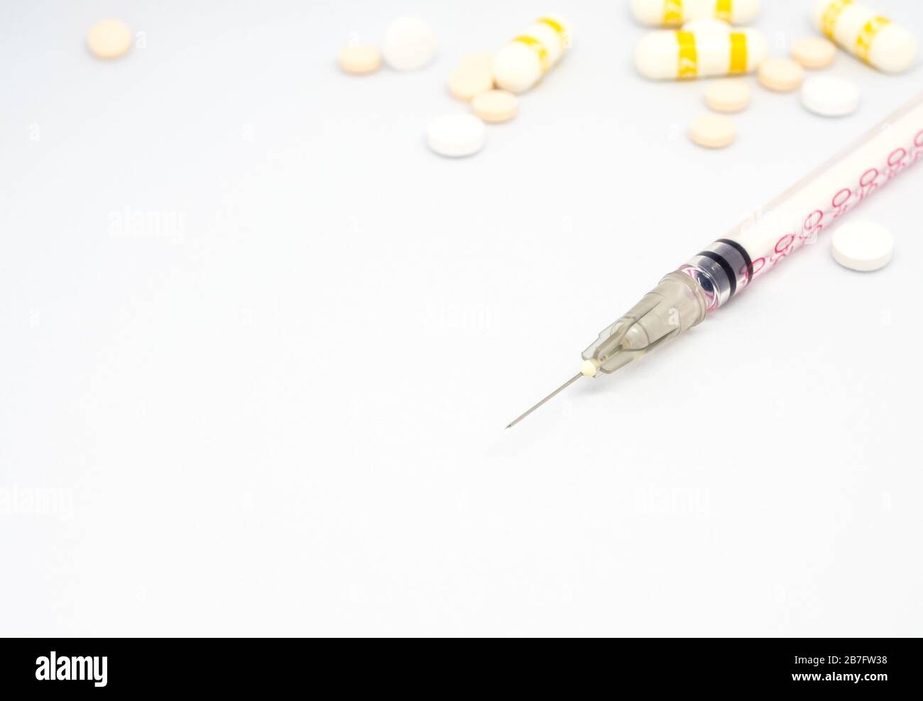 Syringe, injection needle and some pill on white background Stock Photo