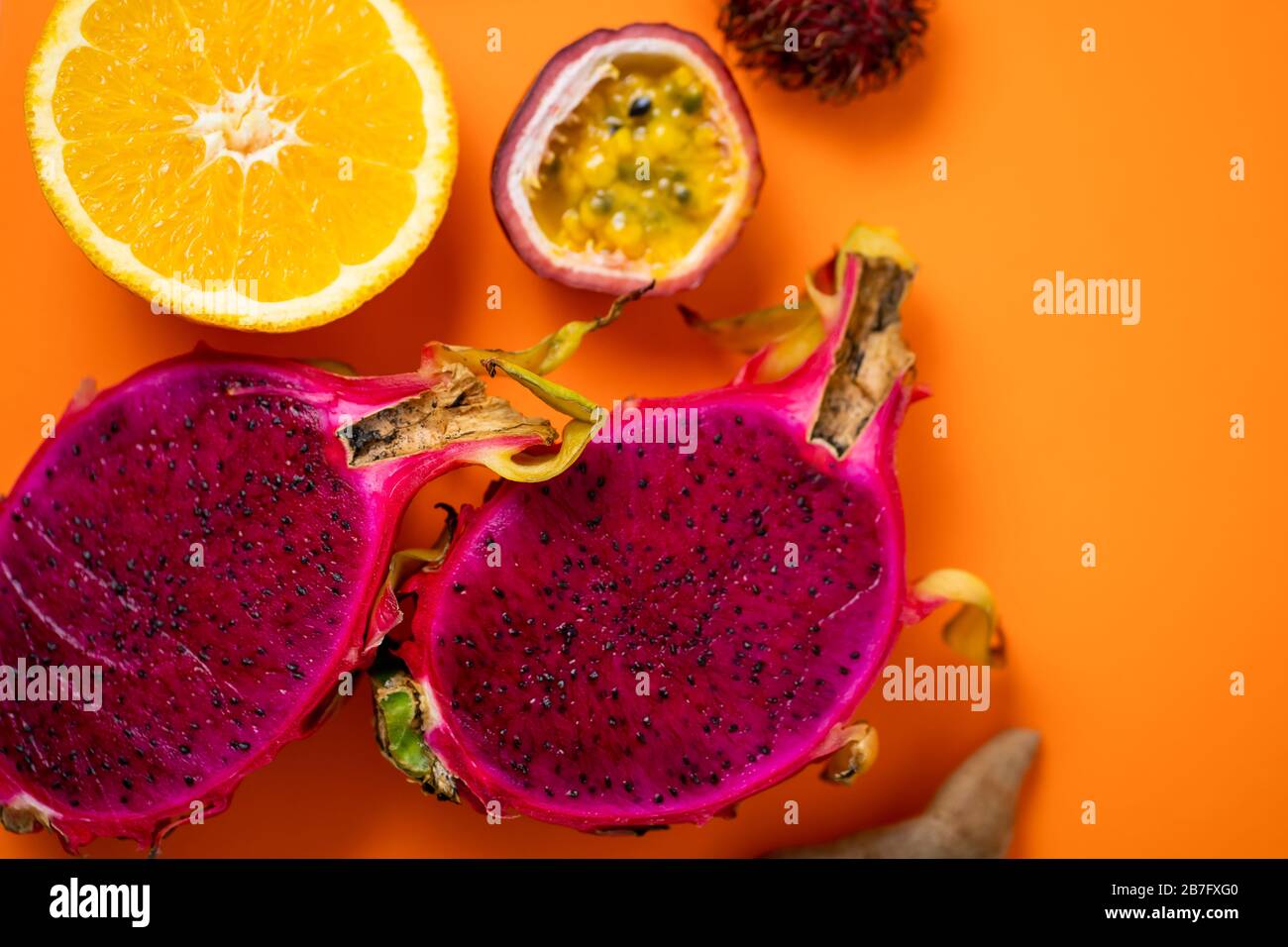 Close up shot of halves fresh ripe exotic tropical fruits. Dragon fruit,  orange, passion fruit, rambutan on orange background. Top view, flat lay.  Sum Stock Photo - Alamy