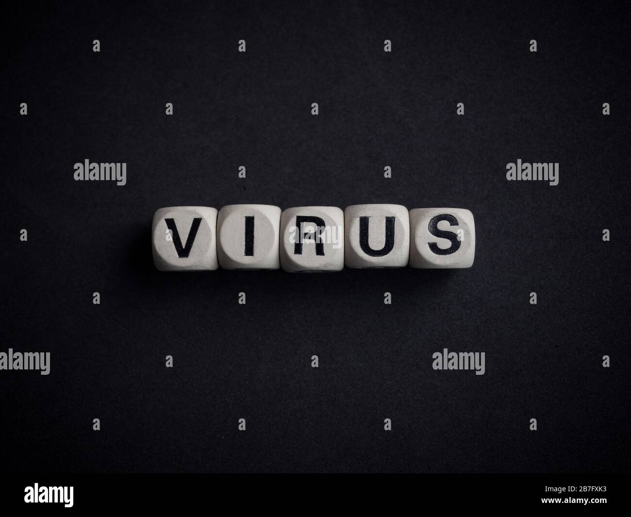 Coronavirus or Covid-19 concept. Wooden cubes text "VIRUS" on dark background. Stock Photo