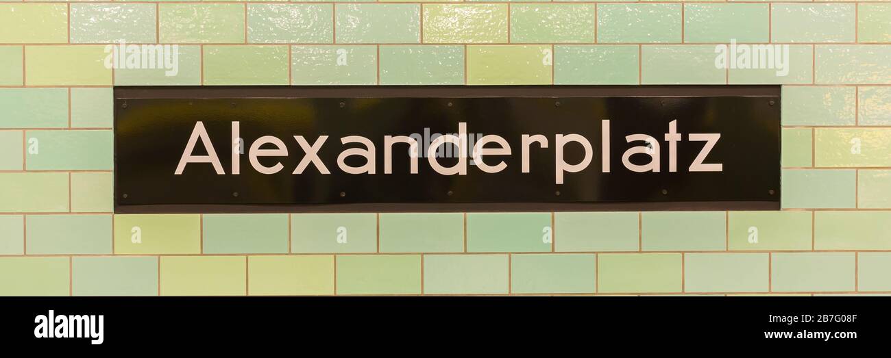 Close up of Alexanderplatz sign at the U-Bahn (metro) station. Black sign with white lettering, surrounded by green tiles. Subway popular for design. Stock Photo