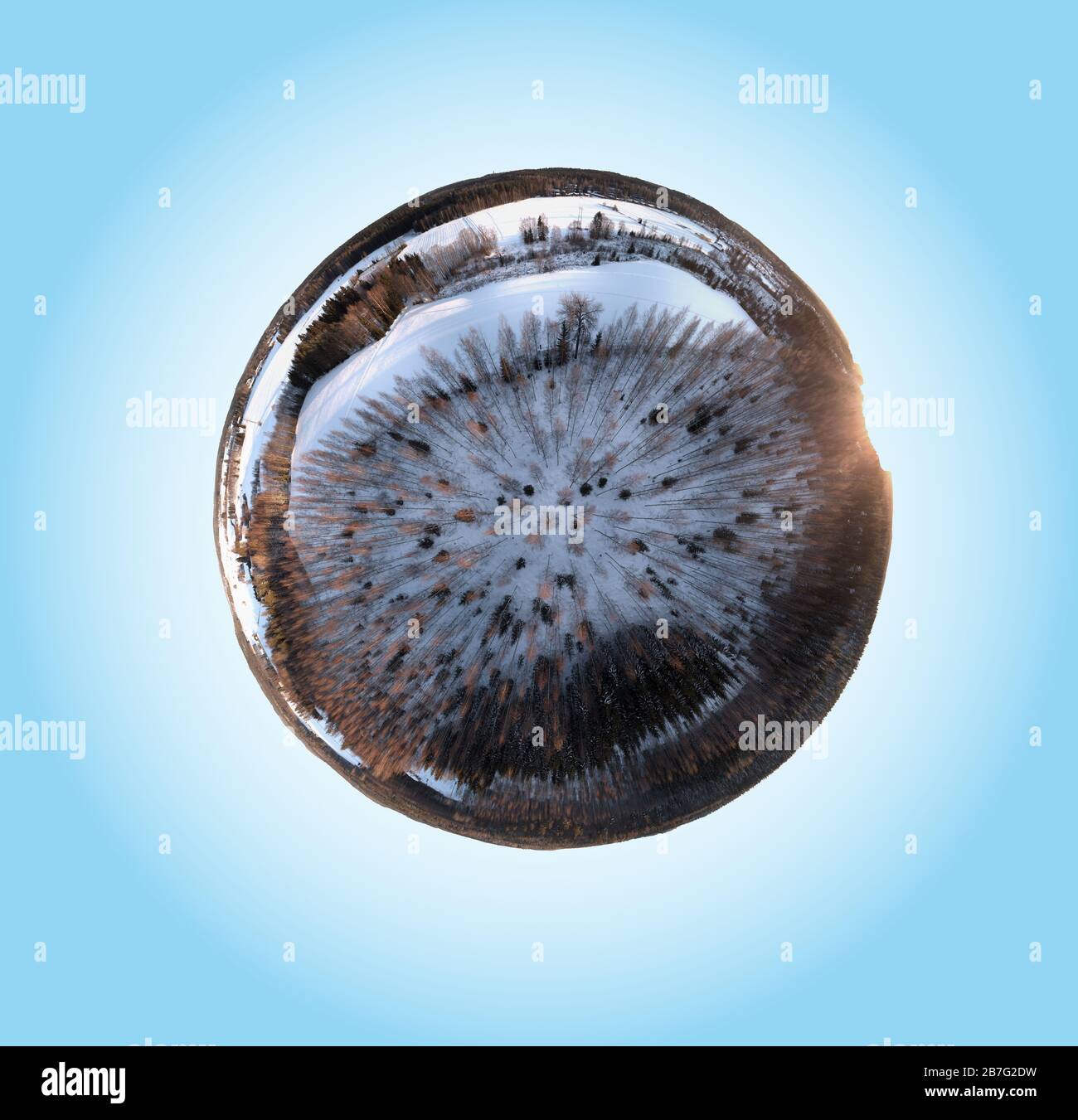 360-degree mini planet panorama of a snowy winter forest in Finland. Snow covered fields and sunlight hitting the trees in evening light. Stock Photo