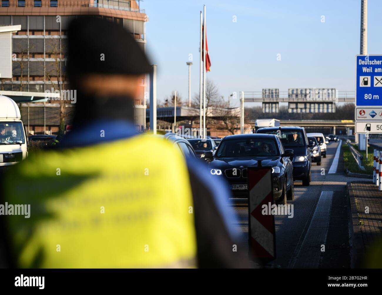 Weil Am Rhein, Germany. 16th Mar, 2020. An official of the Swiss border guard is standing at the border crossing on the A5. In the coronavirus crisis, Germany will introduce comprehensive controls and entry bans at its borders with Switzerland on Monday. Credit: Patrick Seeger/dpa/Alamy Live News Stock Photo