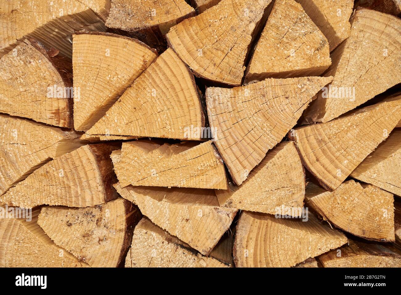 Background image of stacked, dry chopped logs used for firewood. Pile of logs ready to be used in fireplace. Alternative warming method. Stock Photo