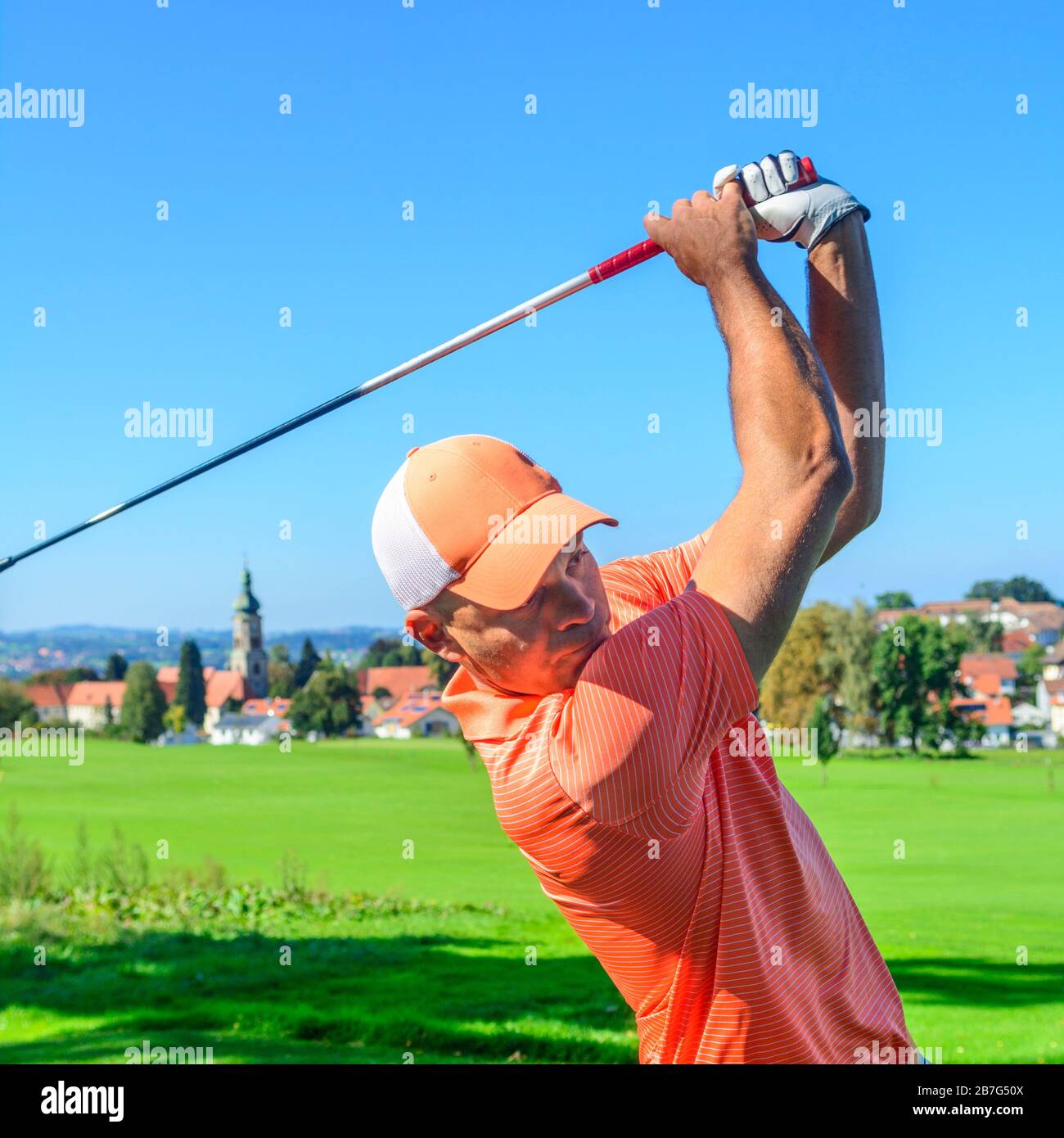 Golf player swinging racket on golf course Stock Photo - Alamy