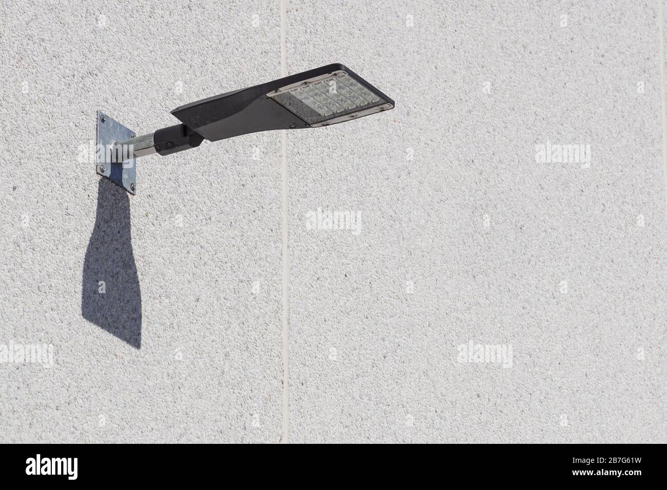 LED fixed on to a bend lamp post in front of a building. The lamp post