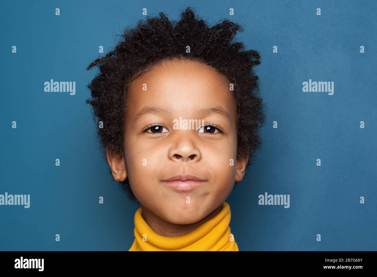 African American child boy face closeup on blue background Stock Photo