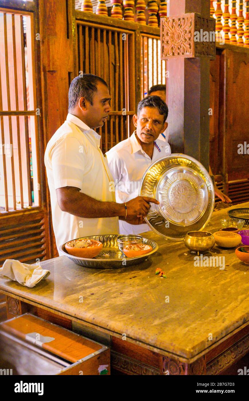 Sri Lanka Kandy Sinhala ancient capital Sri Dalada Maligawa Temple of the Sacred Tooth Relic Buddhist Buddhism interior men clearing offerings Stock Photo