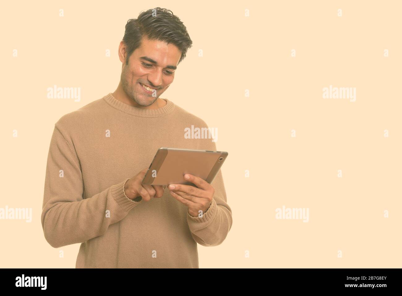 Young happy Persian man using digital tablet Stock Photo