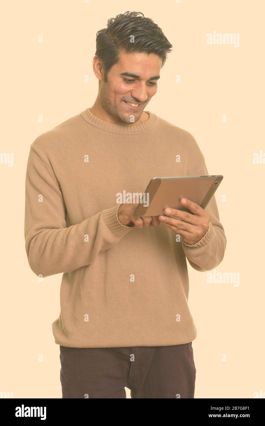 Young happy Persian man using digital tablet Stock Photo