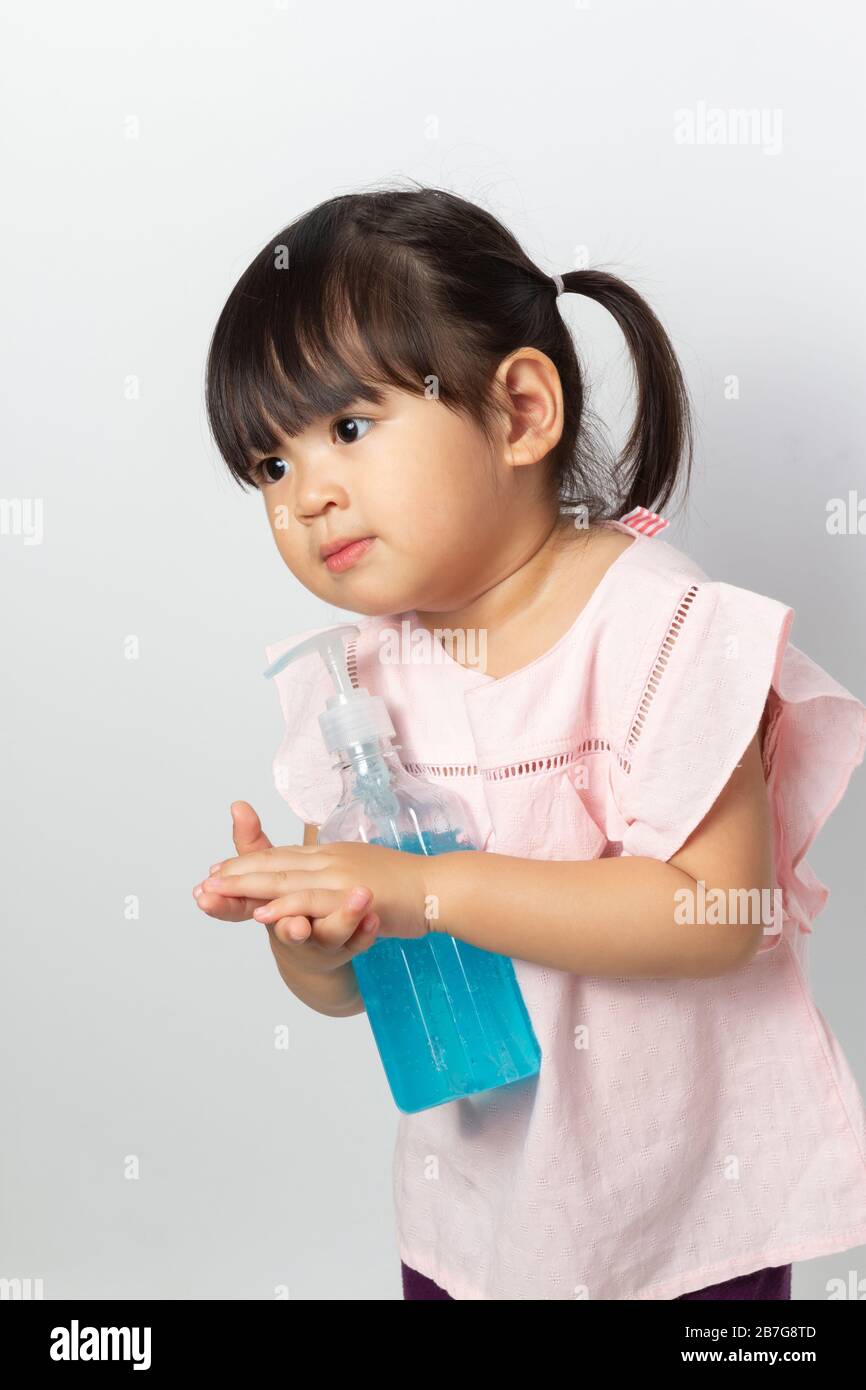 Asian girl using alcohol antiseptic gel for cleaning hands to prevent ...