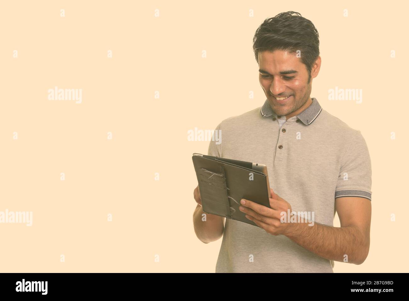 Young happy Persian man using digital tablet Stock Photo