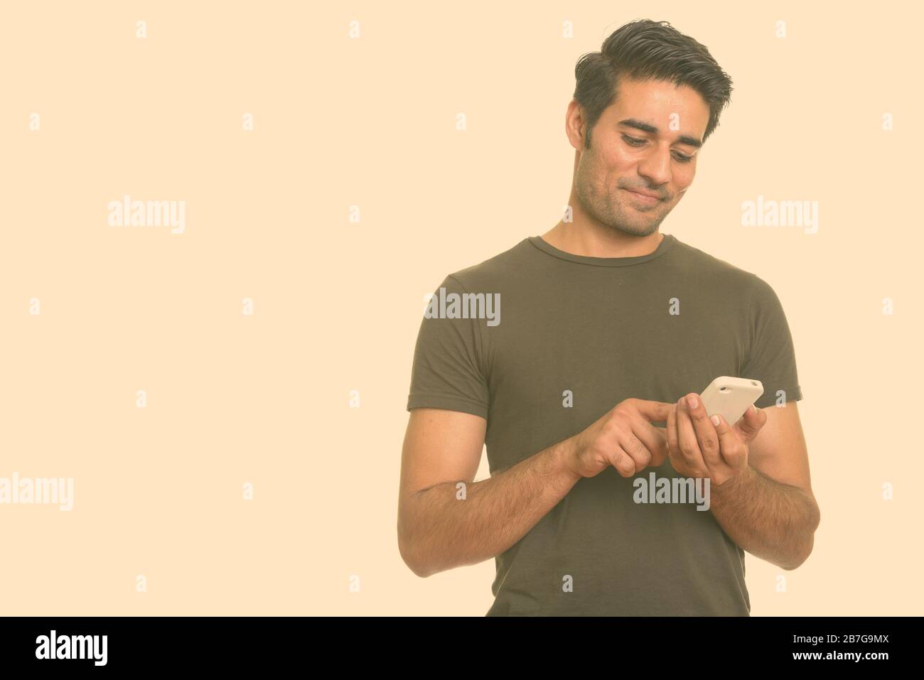Young handsome Persian man using mobile phone Stock Photo