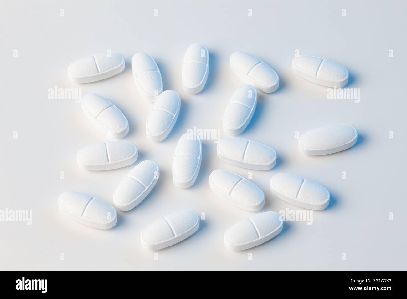white pills on a white background with blue lights Stock Photo