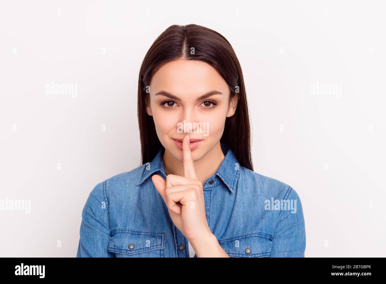 Shhh! Cute beautiful girl touch lips with fingers and keep silence Stock Photo