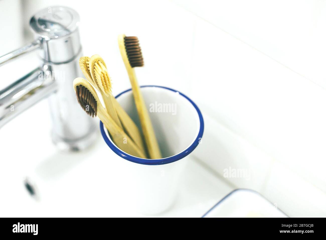 Bamboo wooden toothbrush in metal glass in bathroom interior. No plastic, zero waste, eco friendly concept. Stock Photo