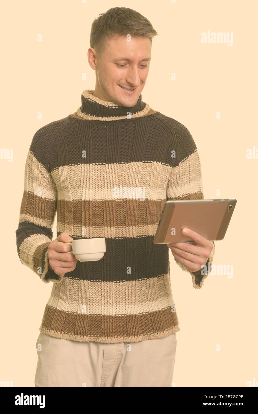 Portrait of happy handsome man with coffee and digital tablet ready for winter Stock Photo