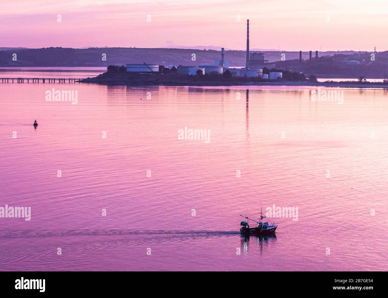 Crosshaven, Cork, Ireland. 16th March, 2020. Fishing boat Muir Einne passing the oil refinery and the power station at Aghada while on her way to the fishing grounds  outside Cork Harbour before dawn.   - Credit; David Creedon / Alamy Live News Stock Photo