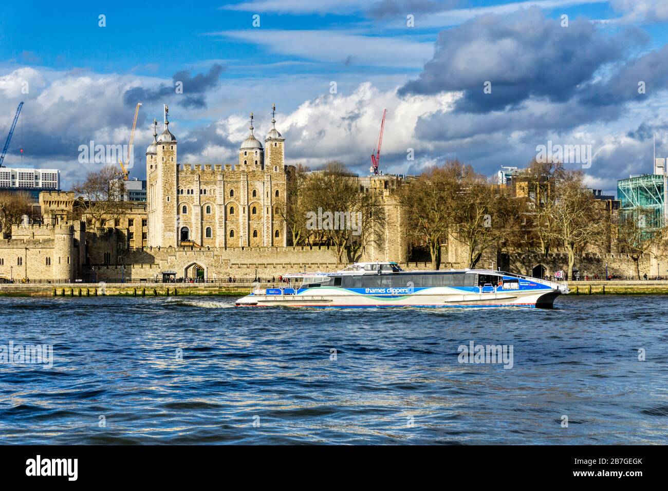 Thames Clipper Tornado on the River Thames passing the White Tower of the Tower of London. Stock Photo