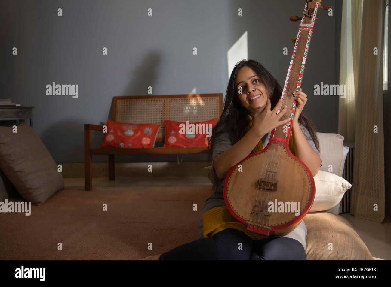 Woman playing music on her tambura Stock Photo Alamy