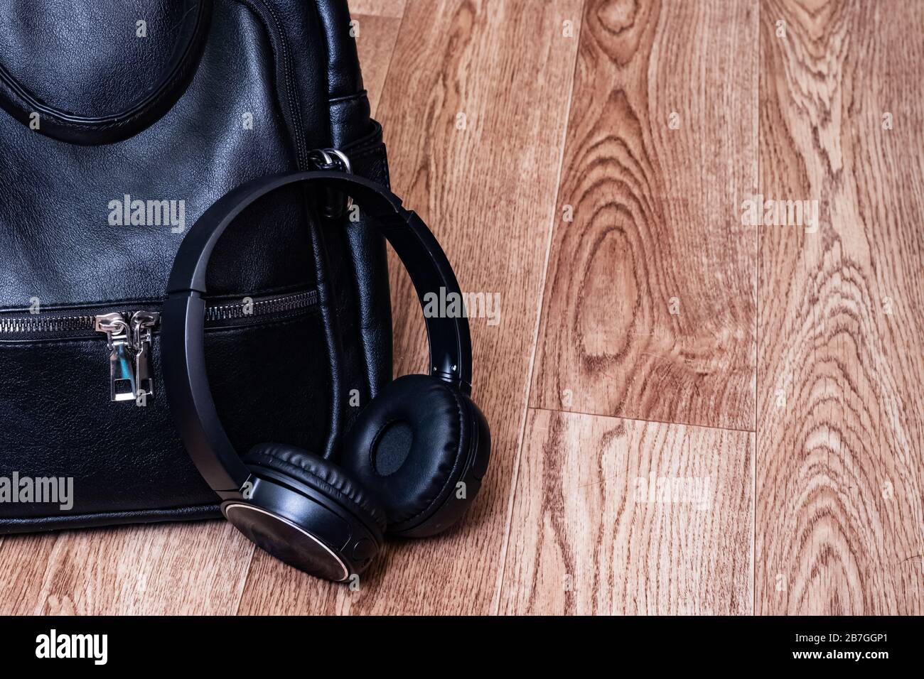 Headphones and leather backpack on wooden floor Stock Photo Alamy