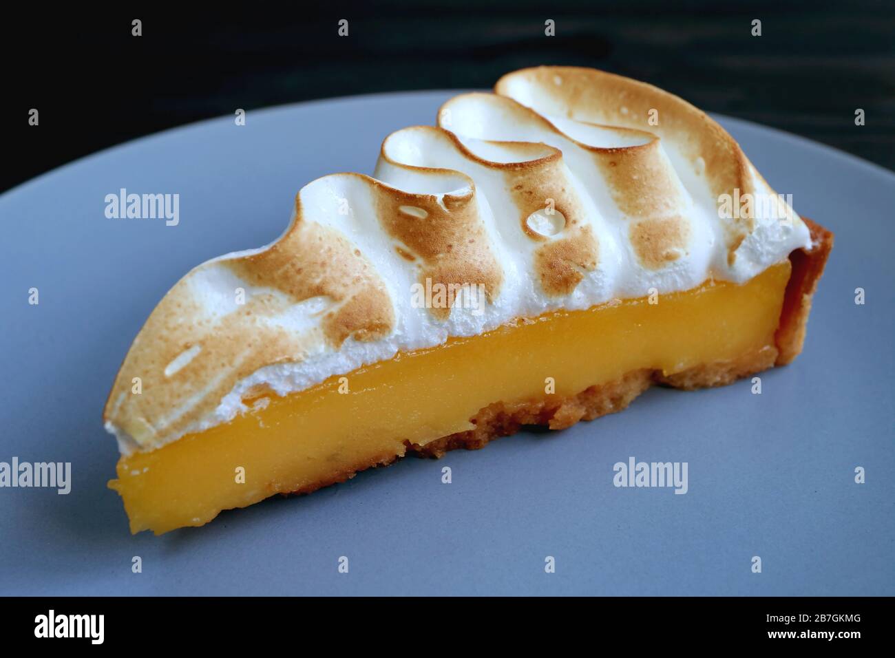 Closeup Tasty Lemon Meringue Tart on Blue Grey Plate Stock Photo