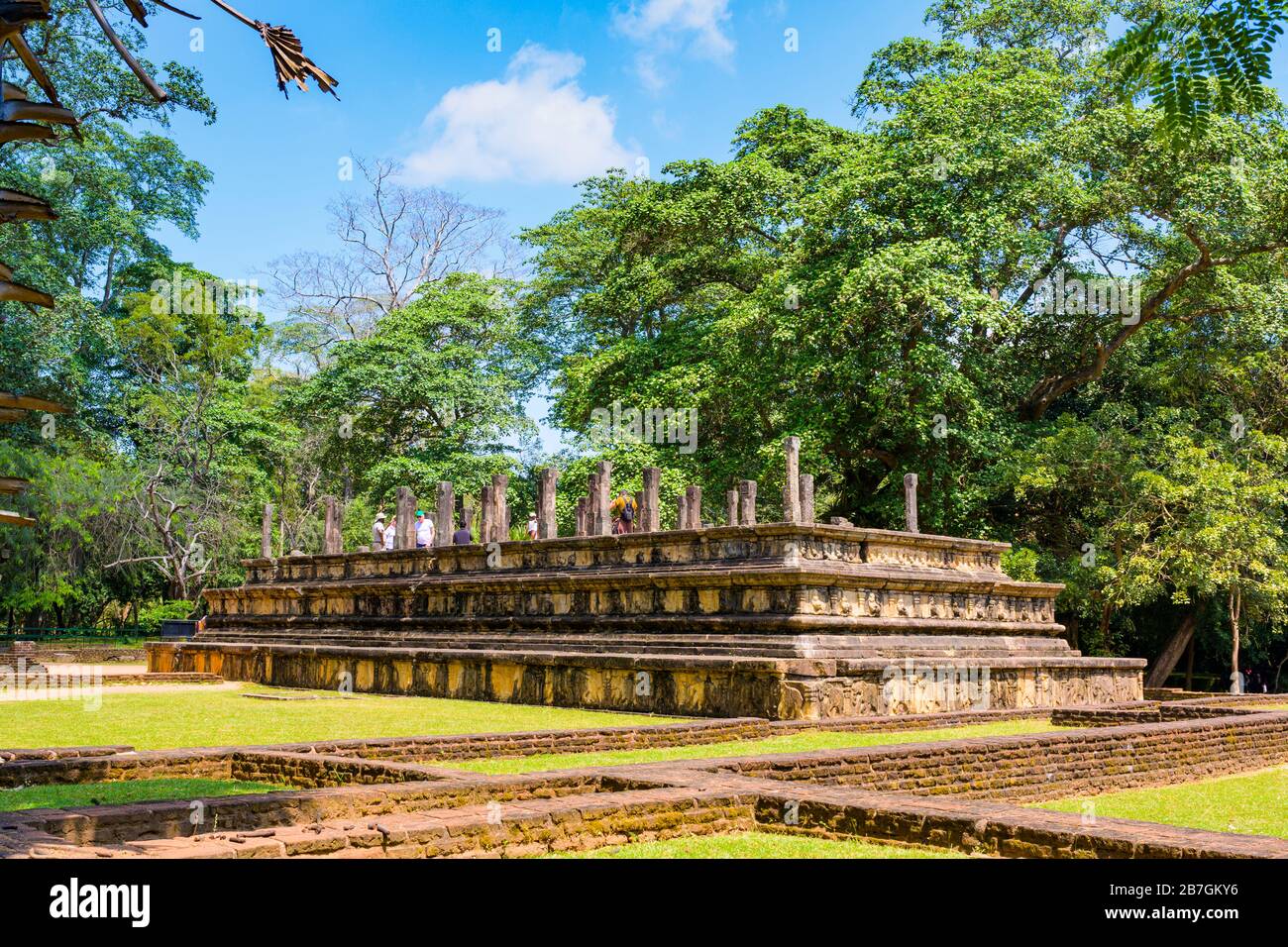 Asia Sri Lanka Polonnaruwa Royal Court of King Parakramabahu 3 layers pillars columns tourists trees blue sky Stock Photo