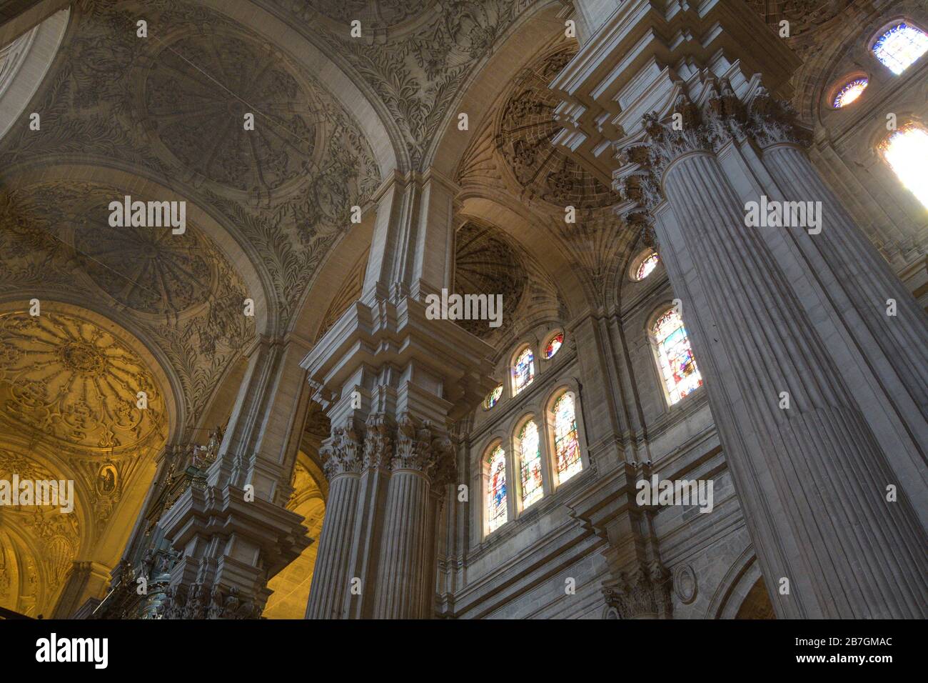 Large pillars, vaults and stained glass windows in Malaga Cathedral