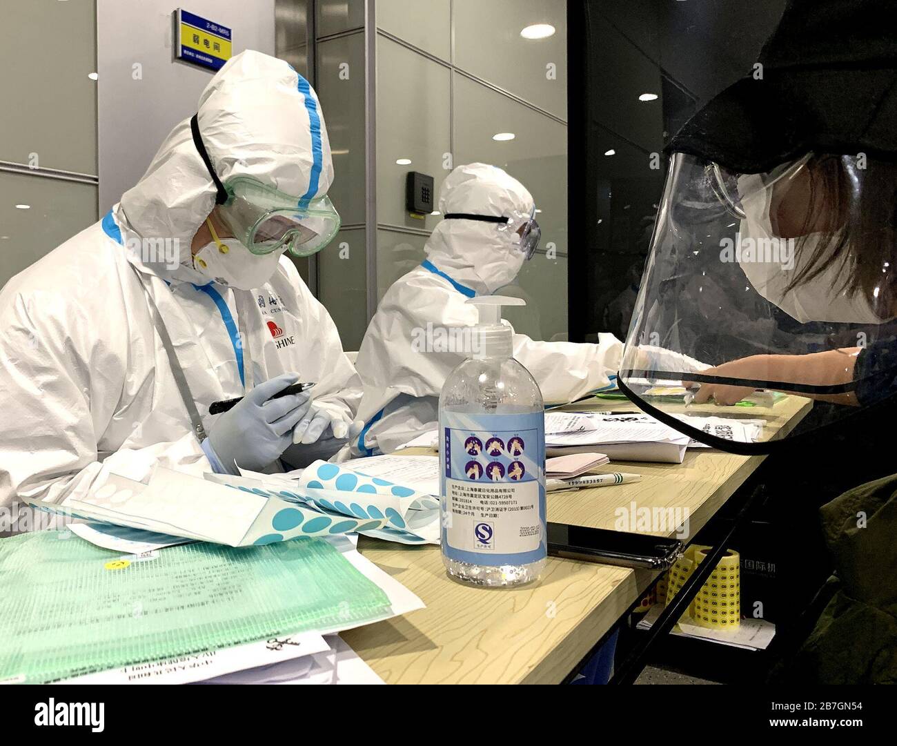 Beijing, March 15. 16th Mar, 2020. Staff members inquire information of passengers at the Shanghai Pudong International Airport in Shanghai, east China, March 15, 2020. TO GO WITH XINHUA HEADLINES OF MARCH 16, 2020. Credit: Yuan Quan/Xinhua/Alamy Live News Stock Photo