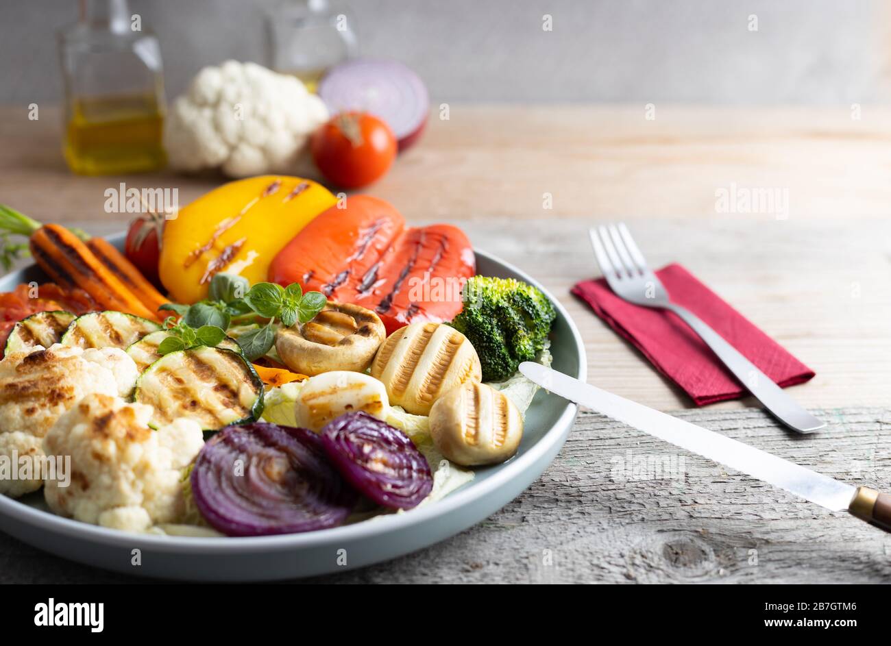 Organic grilled vegetables bell pepper, cauliflower,broccoli,carrots,mushrooms and red onions served on a round plate. Vegetarian dinner serving of ro Stock Photo
