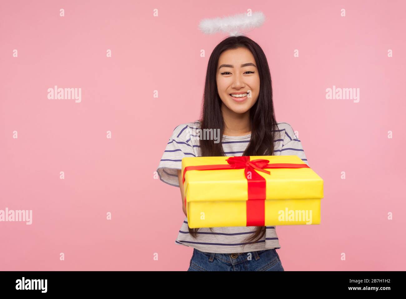 Charity and donations. Portrait of angelic asian girl with halo over head  giving gift box to camera and modestly smiling, expressing kindness,  generos Stock Photo - Alamy